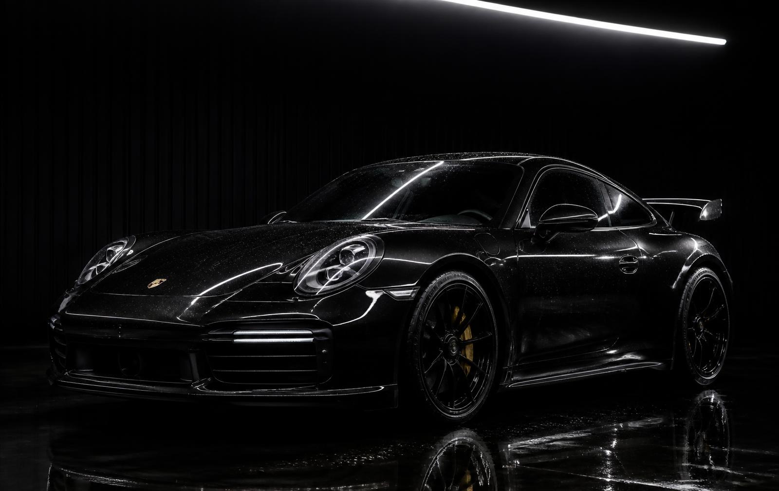 Freshly detailed black sports car under studio lighting